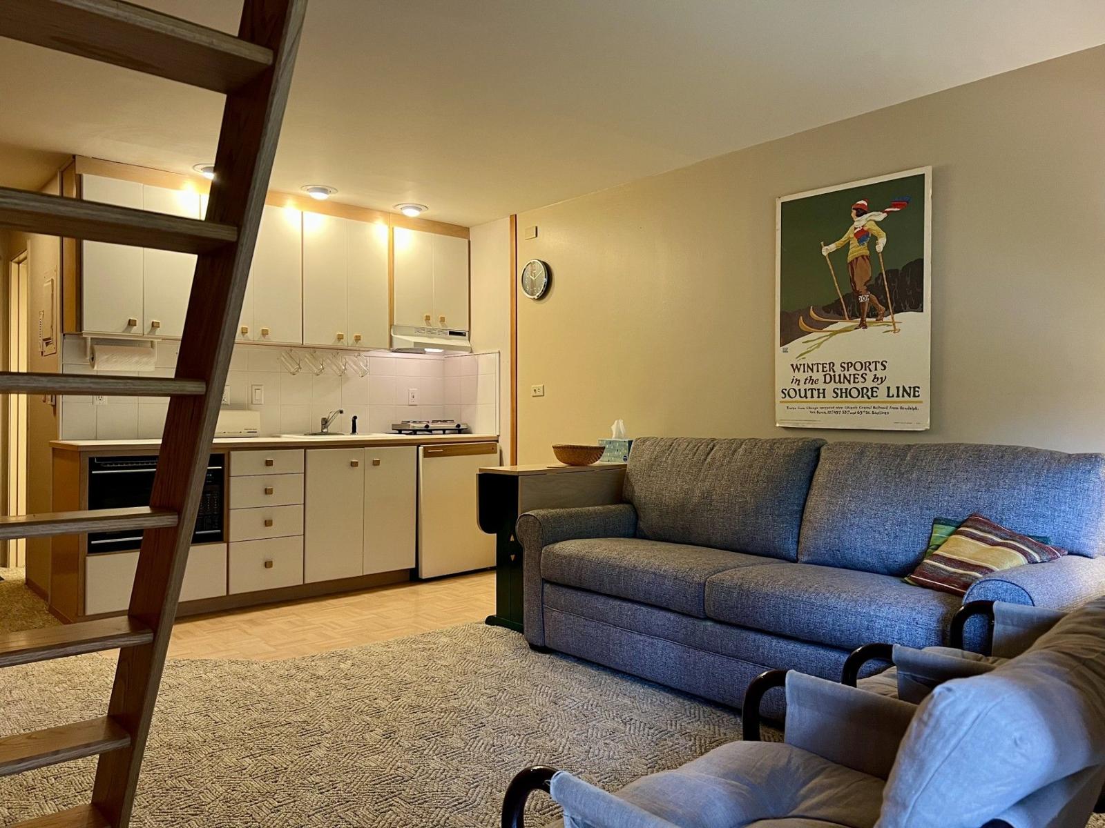 Great room with couch and kitchen behind